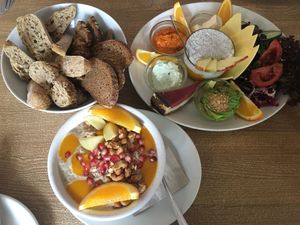 Hot Hafer Porridge mit Mangosauce und gerösteten Cashewkernen und Manas Big Breakfast mit Paprika-Dip, Frischkäse, Avocado, Käse, Kuchen at Mana - Schöneberg in Berlin