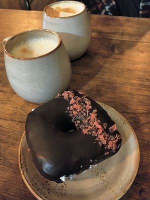 Pistachio latte and chocolate raspberry doughnut at Bite Me Cafe in Madrid