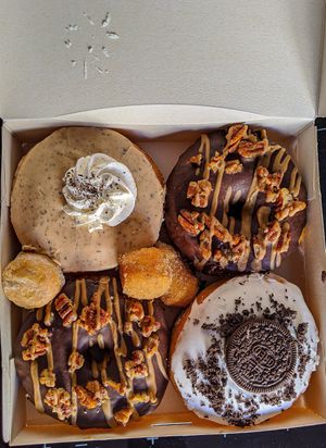 A box of "Yes, please!" 🌱🍩🍩🍩🍩🌱😍 at Bite Me Cafe in Madrid