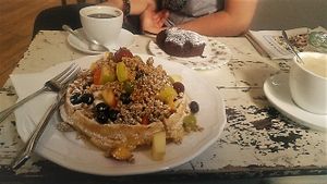 Vegan chocolate cake, capuccino with soy milk, vegetarian breakfast (waffle with lots of fruits!) and vegetarian latte. at Amelie Cafe & Dekoration in Saarlouis