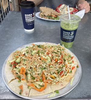 My Phuket pizza and oatmilk matcha latte (with brown sugar cinnamon syrup) and my partner’s chickpea salad sandwich and oatmilk coffee latte  at River Rock Roasting Company in La Verkin