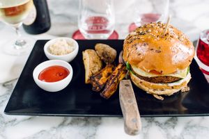 Seitan burger with vegetables, plant-based cheese, sauerkraut and wedges at Wulf & Lamb Chelsea in London