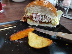 The Wulf Burger [£14.95] - Seitan patty, tomato, baby gem, pickle, red onion, cashew aioli in a brioche bun with sauerkraut, sweet potato and potato wedges.  at Wulf & Lamb Chelsea in London