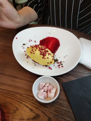 Mango & Passionfruit Cheesecake [£ 6.95] - Served on a base of macadamia, pistachios and sesame seeds topped with raspberry crumble at Wulf & Lamb Chelsea in London