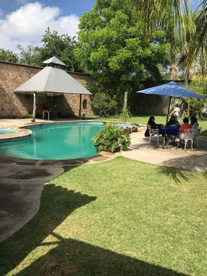 Tables around the pool in a beautiful garden at Ol-Lin Vegan in Ajijic