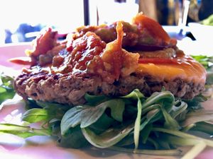 The Impossible Burger on a bed of arugula with cherry tomato jam and avocado at Kuma's Corner in Schaumburg