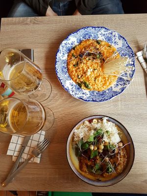 Tomato risotto with hazelnuts and almond "ricotta" and curry tempeh with rice, accompanied with delicious Belgian beer. at Charlotte's by De Brugsche Tafel in Bruges