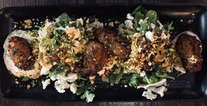 Cauliflower, coriander & quinoa fritters on lentil, dates & green olive salad w/ tahini lemon dressing, dukkah & herbed coconut yoghurt at Atticus Finch in Rotorua