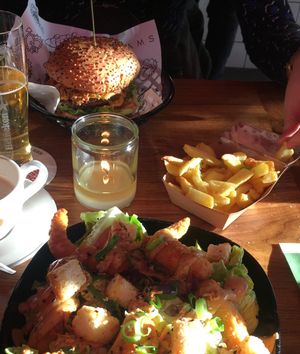 Shrimp salad, cheese burger, fries, coffee, and beer. at Vegan Junk Food Bar - De Pijp in Amsterdam