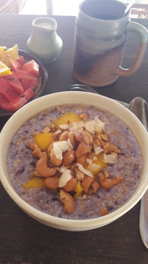 Porridge with seasonal fruit, cashews, dates, candied ginger. Vegan option coconut milk. at Eden Eco Village in Kampot
