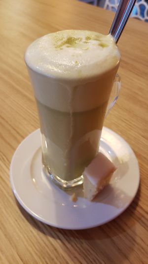 Matcha latte with a piece of lemon cake at be Well in Bochum