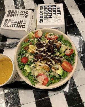 Caesar salad. On the left is the cheese sauce for dipping fries in. My friend also got loaded mushroom fries (box) at Beatnic - Rockefeller Plaza in New York City