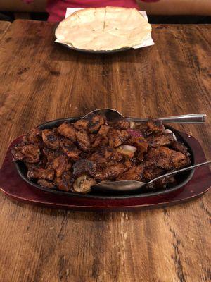 Vegan beef sizzler with garlic cheese bread in background.  at Mr Singh's in Wolverhampton
