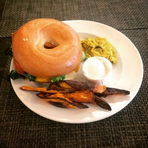 Delicious sausage bagel, tofu scramble and sweet potato fries with chilli mayo. All vegan.  at Plantbase Cafe in South West London