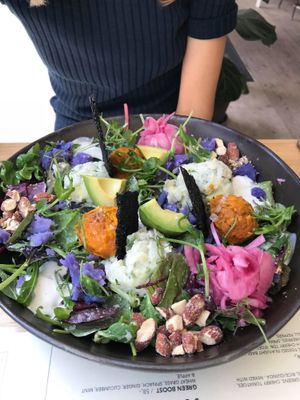 Power bowl with different types of potatoes and greens in a tahini dressing, pickled red onions, crackers and roasted almonds at Plant Power Food in Copenhagen
