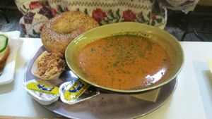 Amazing coconut milk and red pepper soup and plain bagel! Ignore the butter packets. at Li O Lait in Bruges