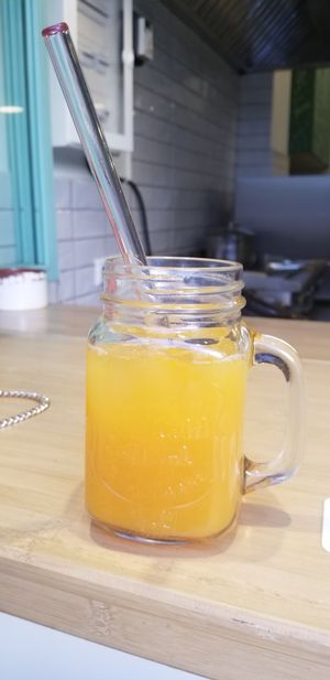 Orange juice with glass straw at Peas in Athens