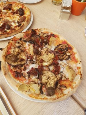 Pizza with aubergine, artichoke, dried tomatoes, fresh olives and vegan mozzarella at Coogi's Restaurant in Mdina