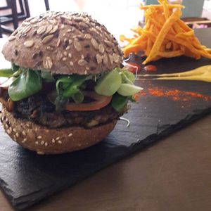 Delicious lentels and quinoa burguer with potato chips.  Curry and mango sauce but also available with strawberries mayonnaise. Umm delicious at Amaranta Biobar in Valencia