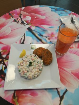 Almond patties with salad and orange carrot juice at bistRAWveg - Cerny Most Shopping Centre in Prague