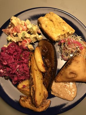 Mix of Sambosa, aubergine steaks, potatoes, green banana salad, coleslaw and corn bread at Veggie Galore in Nijmegen