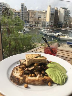Tofu, garlic mushrooms, chickpeas and avocado on toast for breakfast!  at Two Buoys Bistro in St Julians