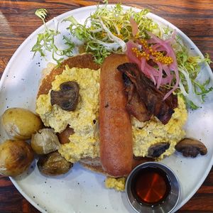 Brunch: pancakes, scrambled tofu, Beyond Meat sausage, original-recipe vegan bacon, potatoes, mushrooms, greens at Aujourd'hui Demain Cafe in Paris
