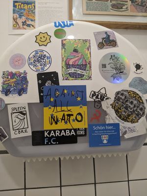 Stickers on the toilet at Aujourd'hui Demain Cafe in Paris