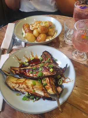 (Top) PATATAS AÏOLI: Roasted new potatoes, homemade aioli, confit garlic, parsley (bottom) Eggplant with soy glaze, sesame seeds & spring onion at Aujourd'hui Demain Cafe in Paris