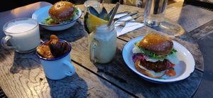An evening meal: two fried chicken burgers, a pina colada, and some potato wedges. at Aujourd'hui Demain Cafe in Paris