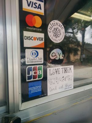 Adding a Happy Cow approved sticker to the Food Trucks window at Murray Hillbilly in Jacksonville