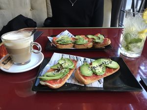 Tostadas de tomate y aguacate (en uno de los platos, con pan sin gluten), café manchado con bebida vegetal y  limonada  at Wild Food in Granada