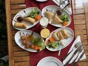 Starters: spring rolls, cheese balls, samosas and seitan starter with maracuya and pineapple lassis  at Os Tibetanos in Lisbon