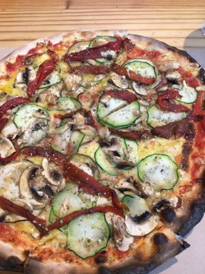 Veggie pizza with lots of vegan cheese underneath the veggies at Pizza Basta Restaurante in Cambrils