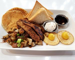 Doug's Slam Platter. Sunny side up tofu eggs, tempeh bacon, white toast, whipped cashew butter, maple syrup, pancakes, and home fries. at Mythology in Toronto