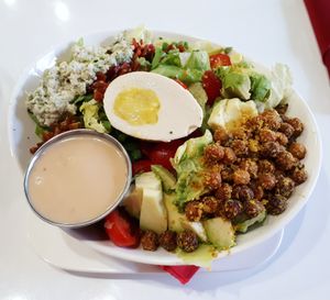 Small vegan Cobb salad...homemade blue cheese crumble, soy bacon bits, vegan hard-boiled egg, crispy cheesy chickpeas, avocado, cherry tomatoes, iceberg lettuce, and red wine vinegar and dijon dressing. at Mythology in Toronto