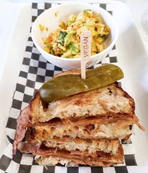 Reuben (rye bread, seitan, Russian dressing, sauerkraut, cashew cheese, and pickle), with creamy coleslaw on the side. at Mythology in Toronto
