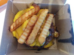 Deconstructed animal burger, 'cause it wouldn't be eaten for a few hours, so could be reheated without bun, lettuce, tomato getting soggy.  Double juicy sausage style patties, with smokey tempeh bacon, layer of crinkle cut fries, sauteed onions, swiss cheese and BarBQ sauce. at Next Level Burger - Concord in Concord