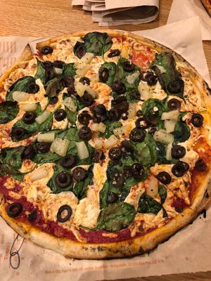 Custom pizza with vegan cheese, gluten free crust, spinach, black olives, and pineapple at Blaze Pizza in Nampa