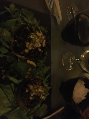 Stuffed portobello mushrooms with black olive tapenade, truffle, salted nuts on a bed of spinach & rocket at Bubbles and Bites in Cascais