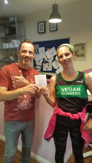 Owner Simon receiving excellent reviews sticker from ambassador Clare at Hillgate Cakery in Stockport
