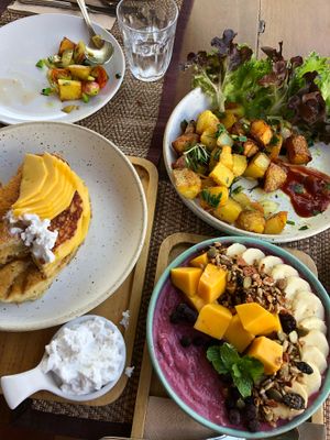 Banana pancakes topped with mango, roasted breakfast potatoes, and berry bowl at Goodsouls Kitchen in Chiang Mai