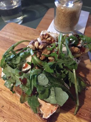 Roasted bread with vegan Camembert, pear, arugula and roasted walnuts 7,50€ at Kuddelmuddel Cafe  in Berlin