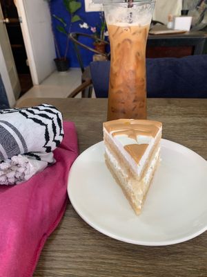 🌏⚖️🇵🇸🤰🏽 Massive Slice of 🕌⚖️ Coconut Caramel Cake 🇵🇸🗝️🌎👩🏽‍🍼, with a tall glass of Coffee🇵🇸🕌🇹🇭🕌🇵🇸 Latte (w at Alchemy Vegan in Chiang Mai
