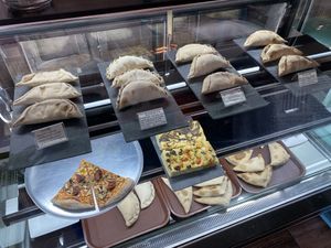 Empanadas, pizza slices and focaccia.  at Pastelería y Panadería Sinfonía in Santiago
