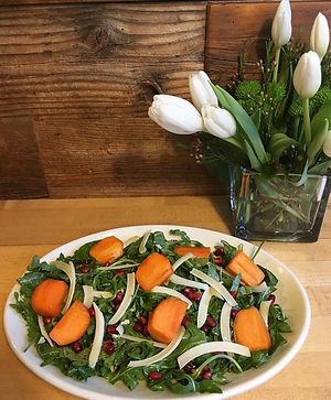 Pomegranate Persimmon salad is made with baby arugula tossed in our house-made shallot vinaigrette, topped with sliced persimmon, pomegranate seeds and shaved parmesan at Zachary's Chicago Pizza in Berkeley