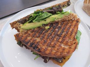 Avo portobello panini. A flax and spelt bread with balsamic portobello mushrooms, avocado, caramelized onions, spinach, basil pesto mayo, and a very delicious cashew cheese.  at Fruitive - Colley Ave in Norfolk