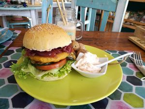 Vegan burger with patatas and homemade vegan aioli (juice with natural straw in background) at Happy Cactus in Fuerteventura