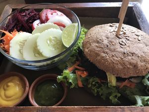 Seitan burger on whole grain bread with a salad.  at La Bruja Vegan Foods in Antigua