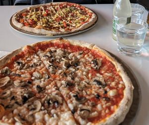 Vegan mushroom pizza and in the back their regular vegan pizza Mexican style. at Olverk Pizza & Brewery in Hveragerdi